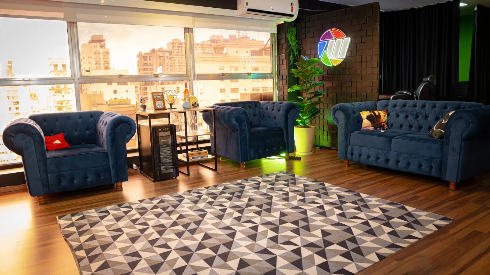Recepção e lounge do Studio A com sofás e vista para São Paulo